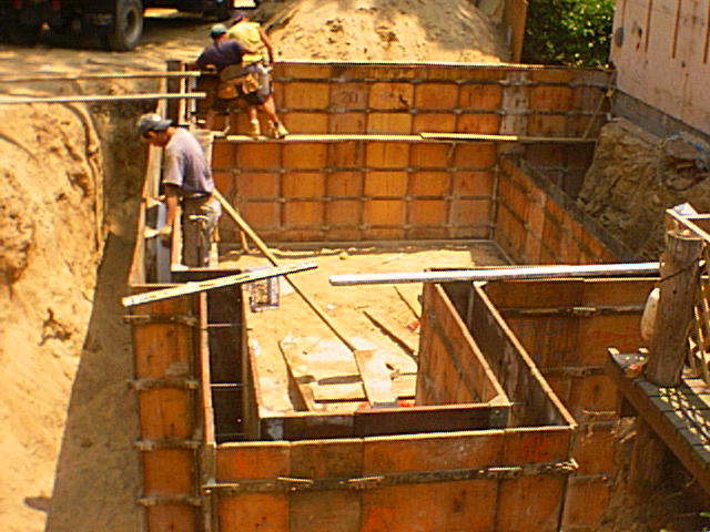 Contractors setting a foundation for a new home